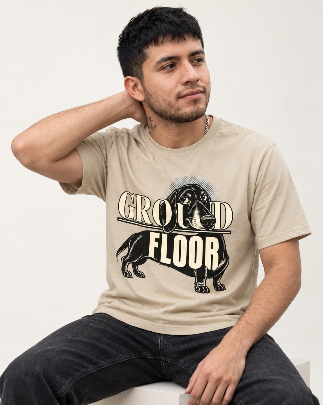 Ground Floor Dachshund T-Shirt in Sand, worn by a seated model