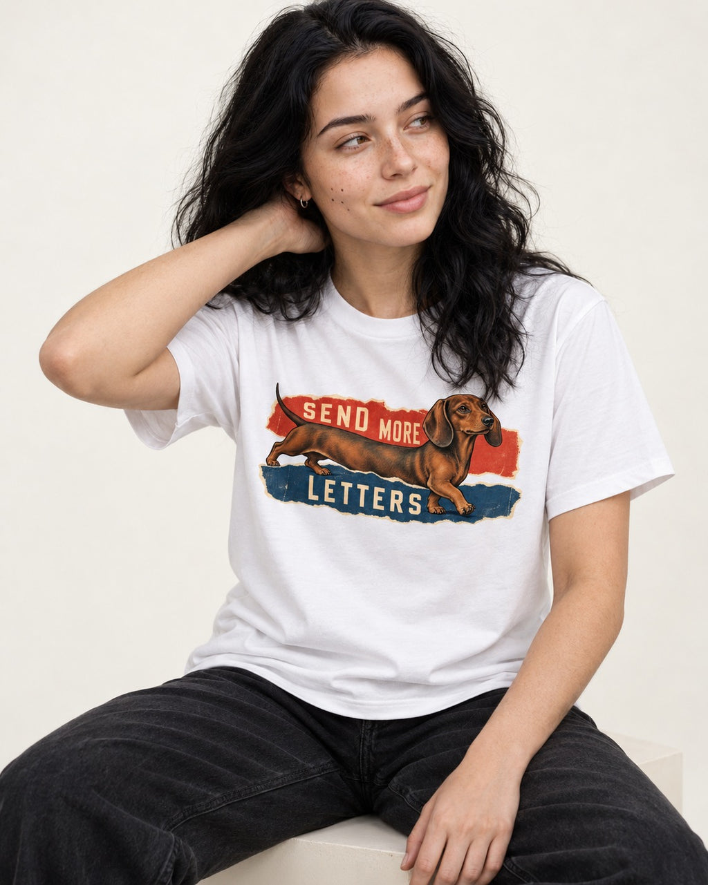 Dachshund Send More Letters Torn Paper Graphic T-Shirt in White, worn by a seated model