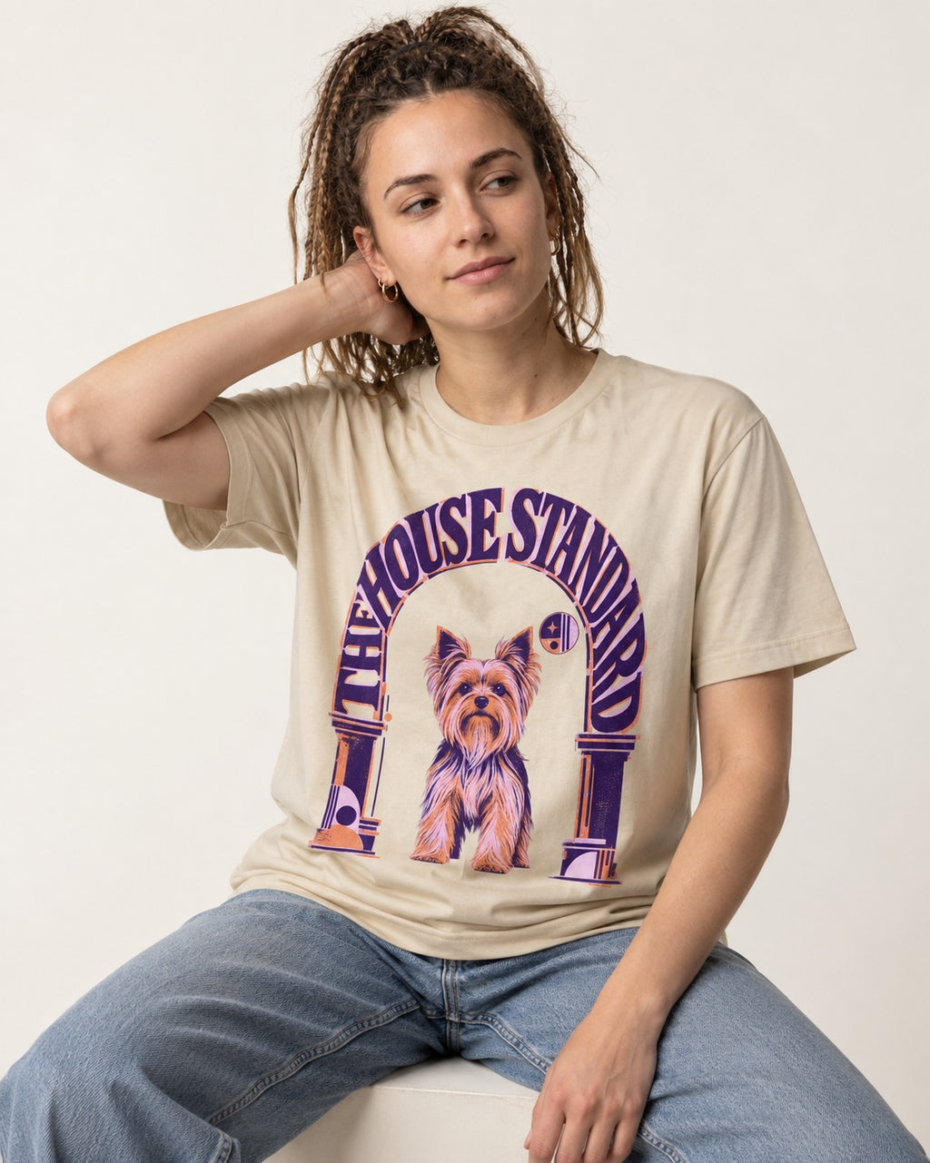 The Yorkshire Terrier House Standard T-Shirt in Sand, worn by a seated model