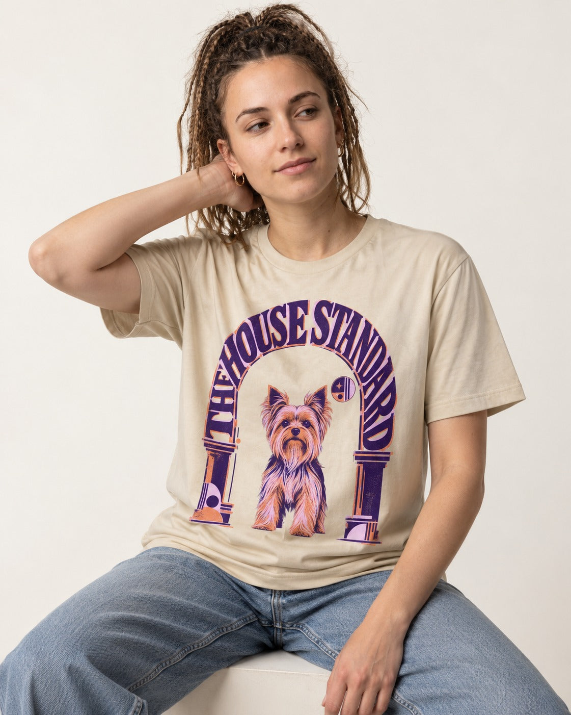 The Yorkshire Terrier House Standard T-Shirt in Sand, worn by a seated model