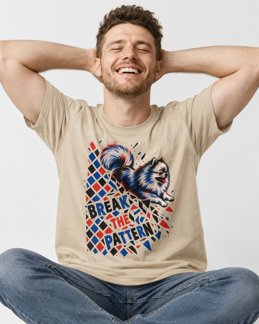 Pomeranian Break the Pattern T-Shirt in Sand, worn by a seated model
