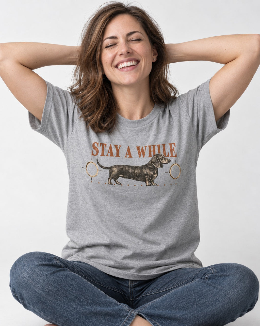 Dachshund Stay A While Ornamental Portrait Graphic T-Shirt in Sport Grey, worn by a seated model