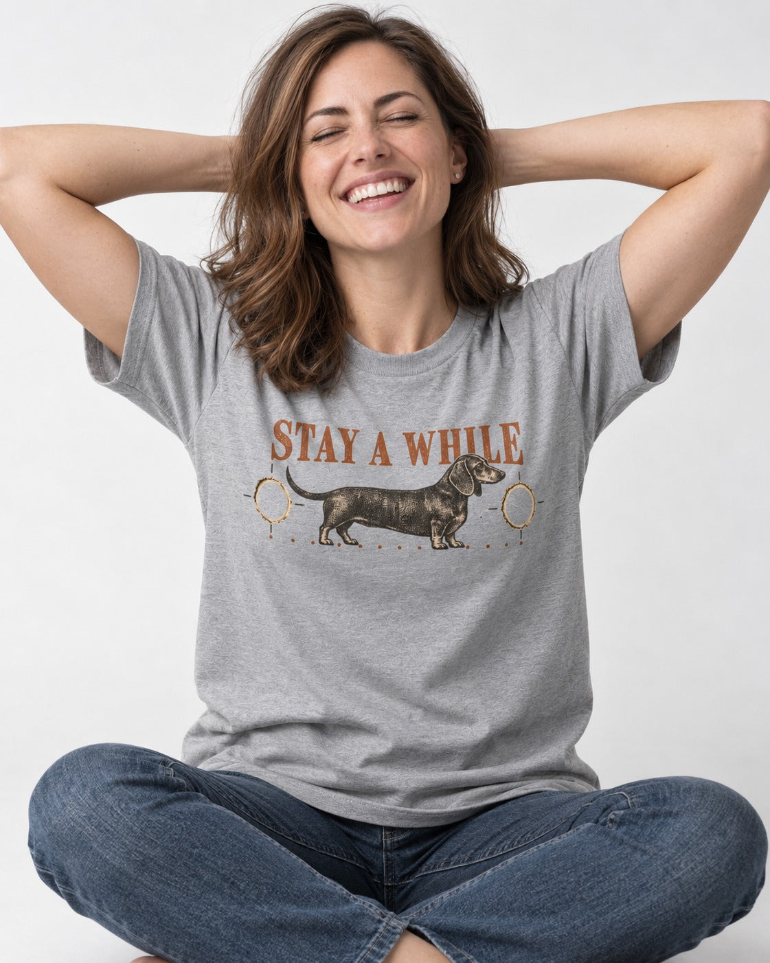 Dachshund Stay A While Ornamental Portrait Graphic T-Shirt in Sport Grey, worn by a seated model