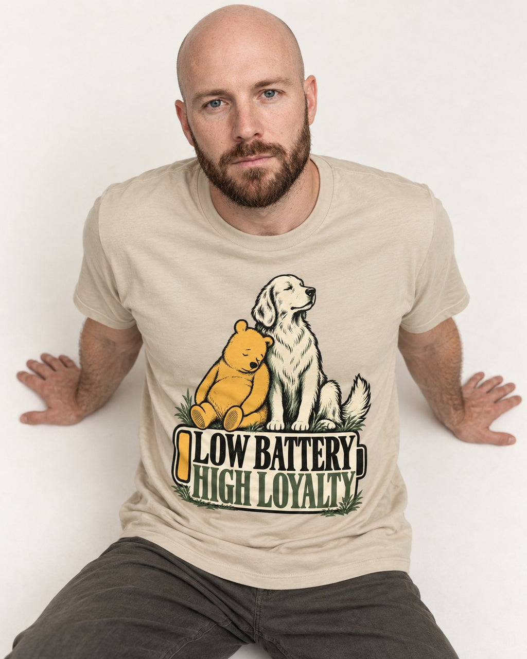Golden Retriever Low Battery High Loyalty T-Shirt in Sand, worn by a seated model