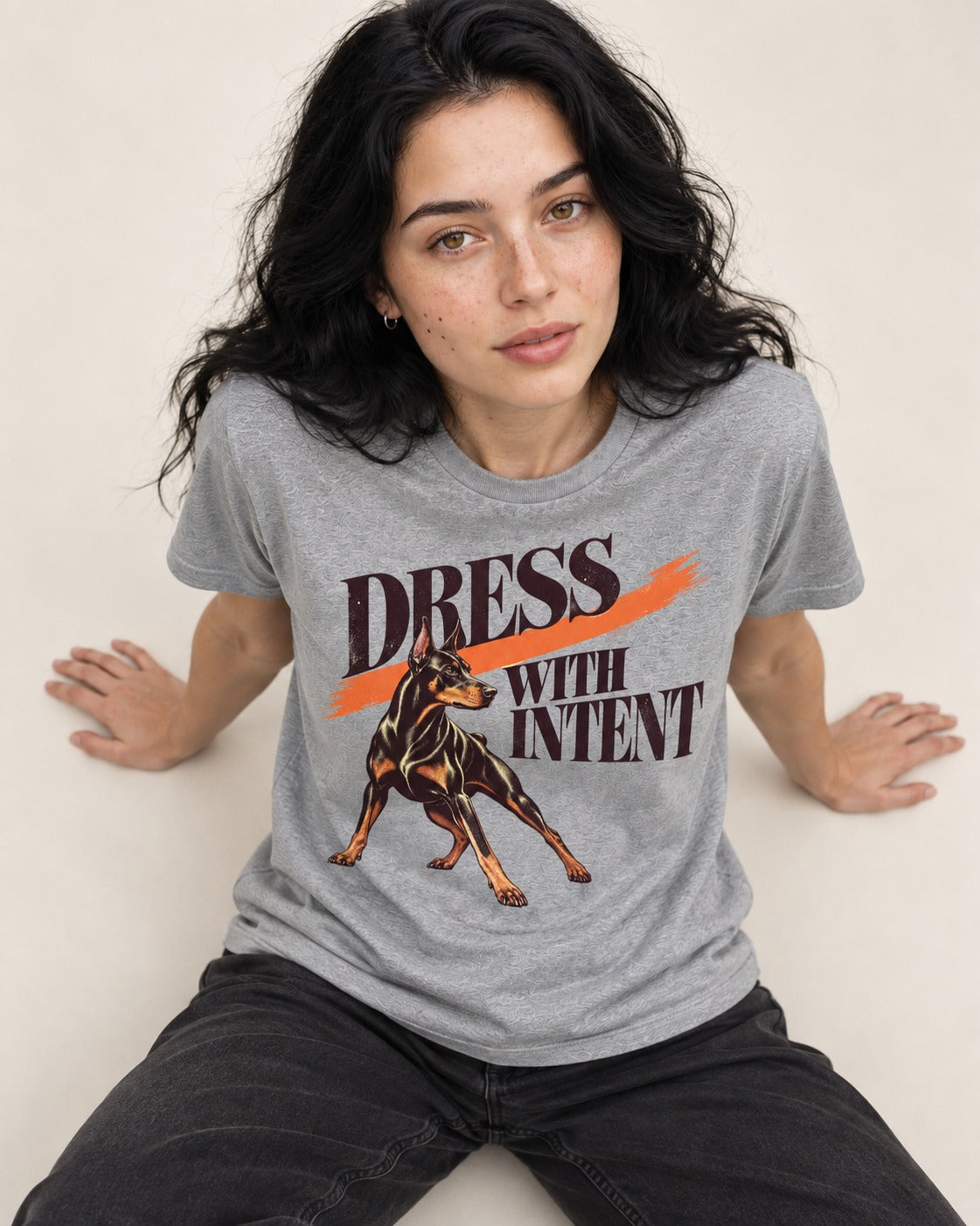 Doberman Dress with Intent T-Shirt in Sport Grey, worn by a seated model