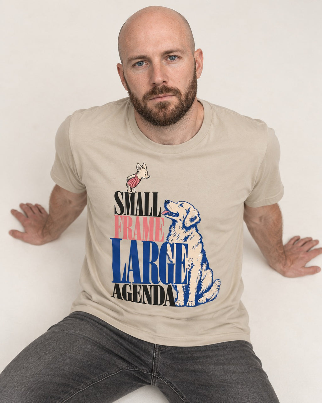 Small Frame Large Agenda Golden Retriever T-Shirt in Sand, worn by a seated model