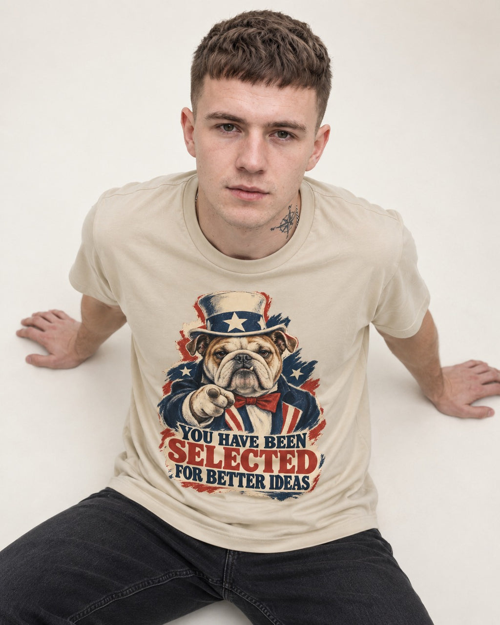 English Bulldog Selected for Better Ideas T-Shirt in Sand, worn by a seated model