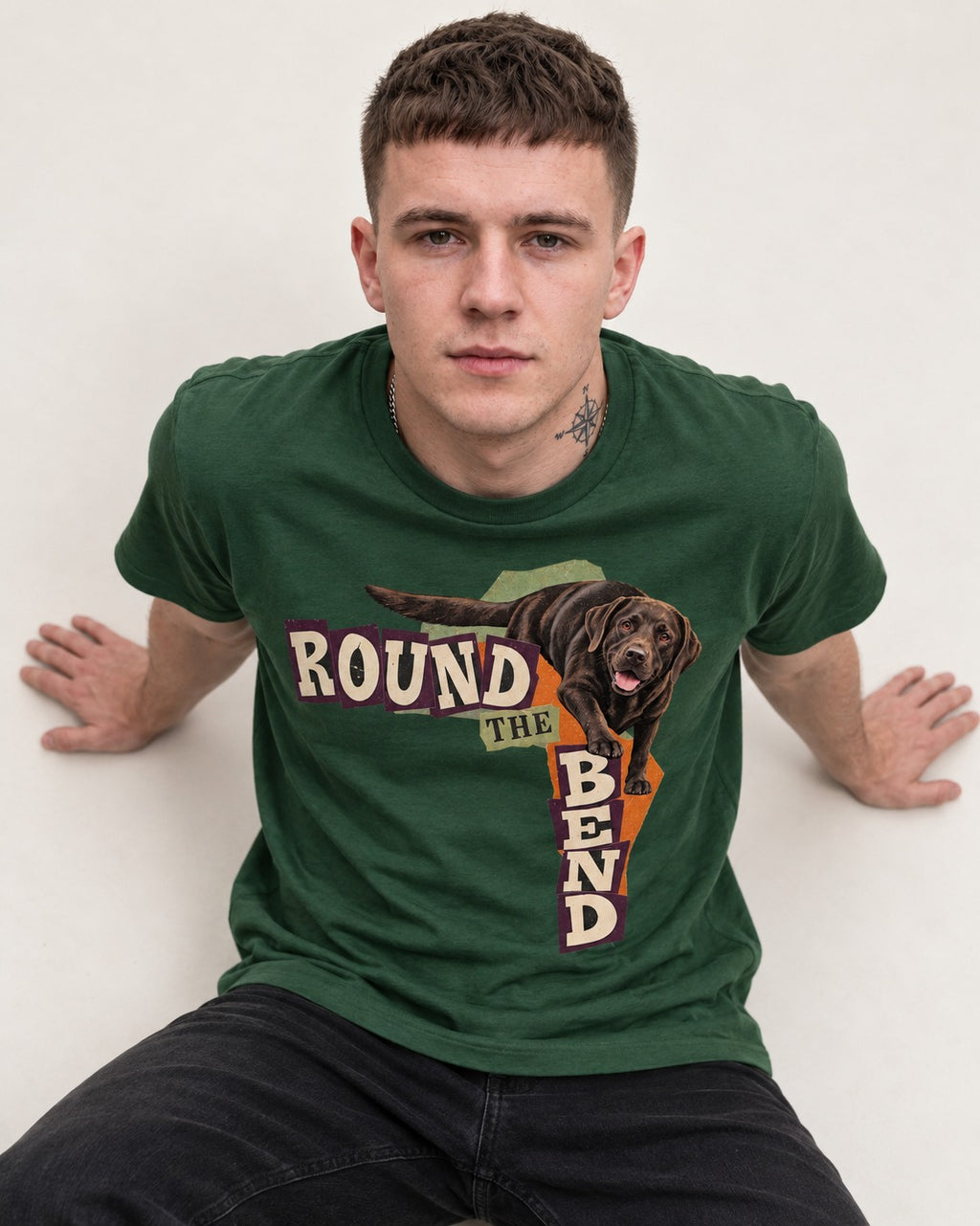 Labrador Retriever Round the Bend Collage Graphic T-Shirt in Forest Green, worn by a seated model