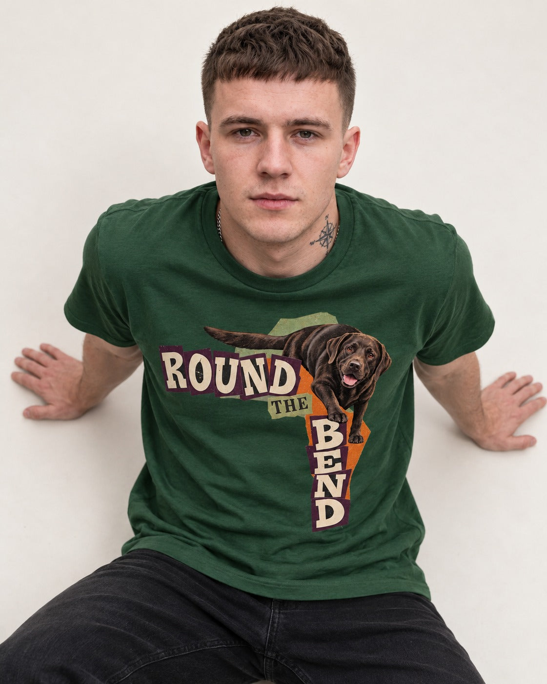 Labrador Retriever Round the Bend Collage Graphic T-Shirt in Forest Green, worn by a seated model