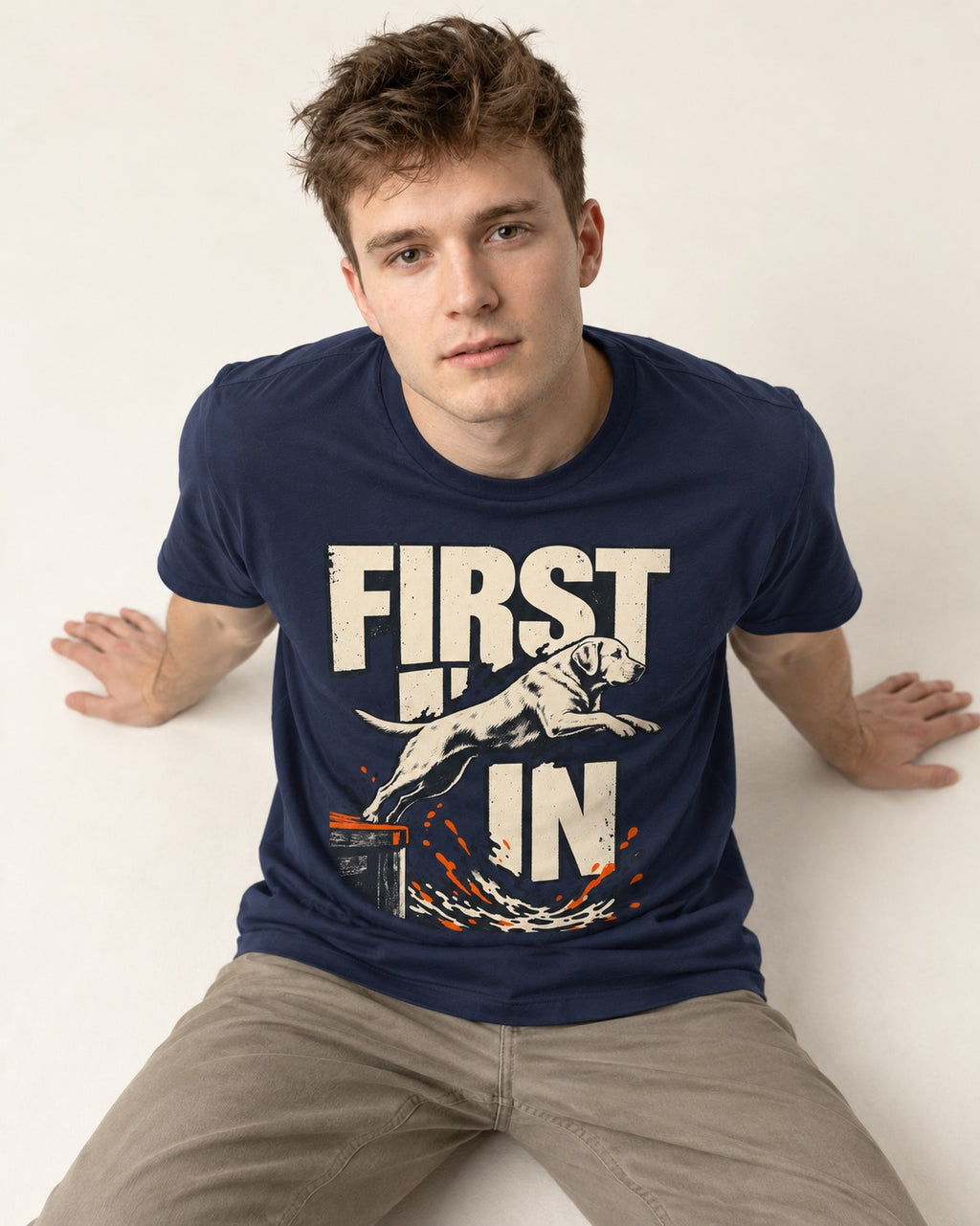 First In Dock Jump Labrador Retriever Graphic T-Shirt in Navy, worn by a seated model
