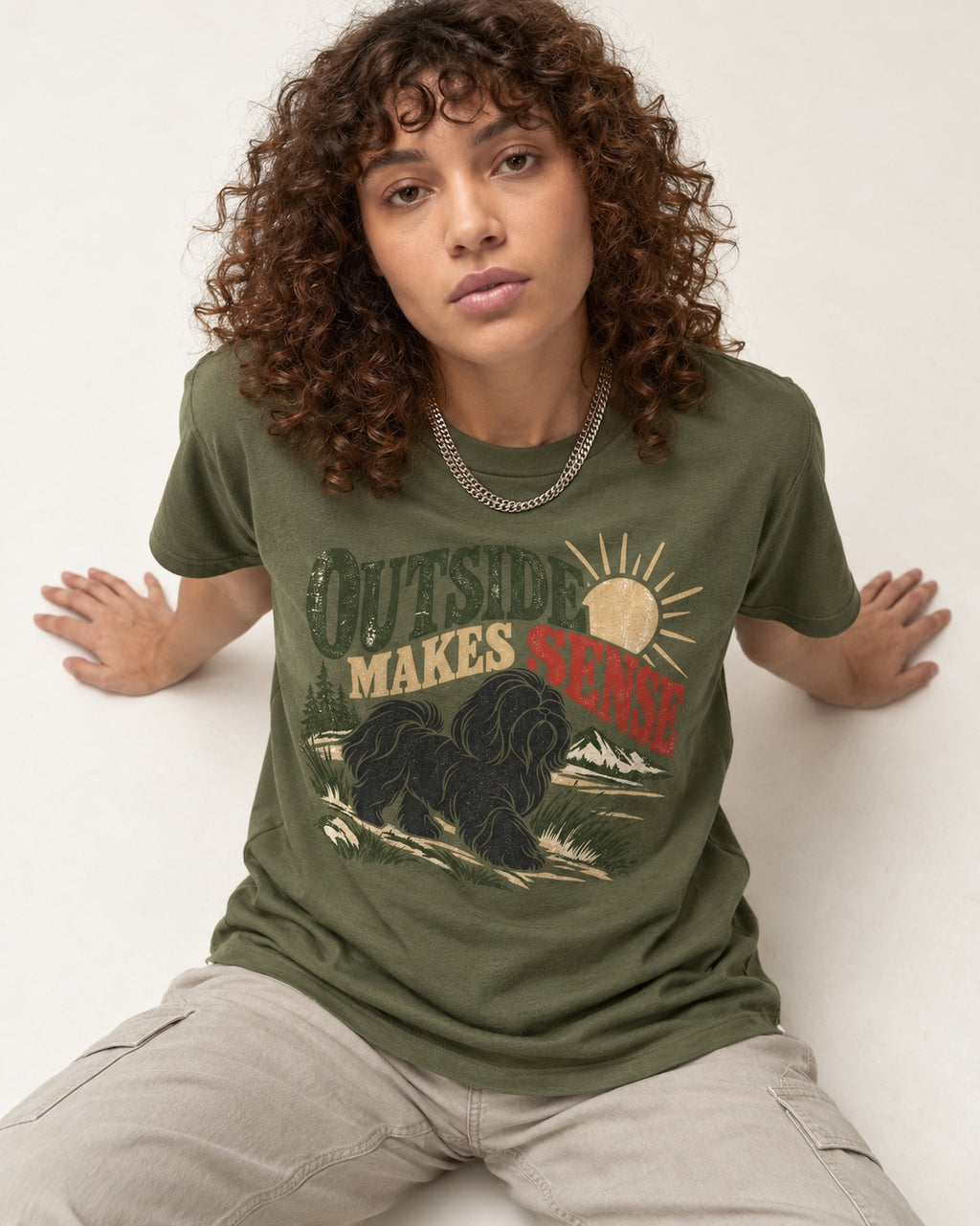 Shih Tzu Outside Makes Sense Mountain Trail Graphic T-Shirt in Heather Military Green, worn by a seated model