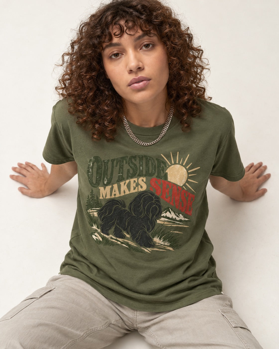 Shih Tzu Outside Makes Sense Mountain Trail Graphic T-Shirt in Heather Military Green, worn by a seated model