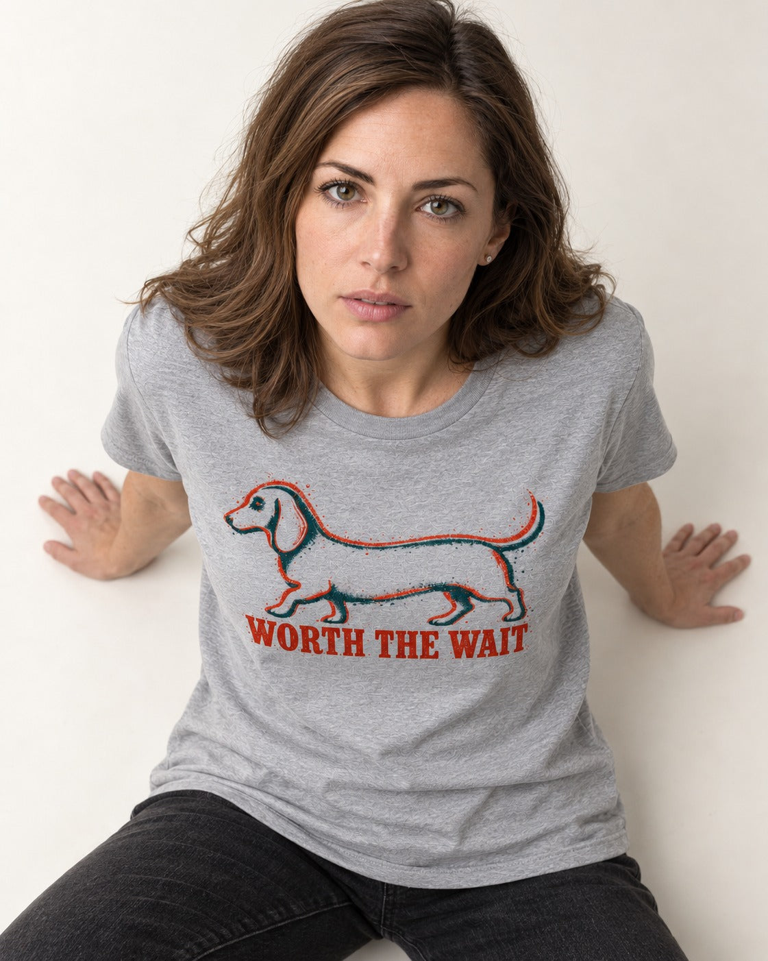 Dachshund Worth The Wait Distressed Outline Graphic T-Shirt in Sport Grey, worn by a seated model