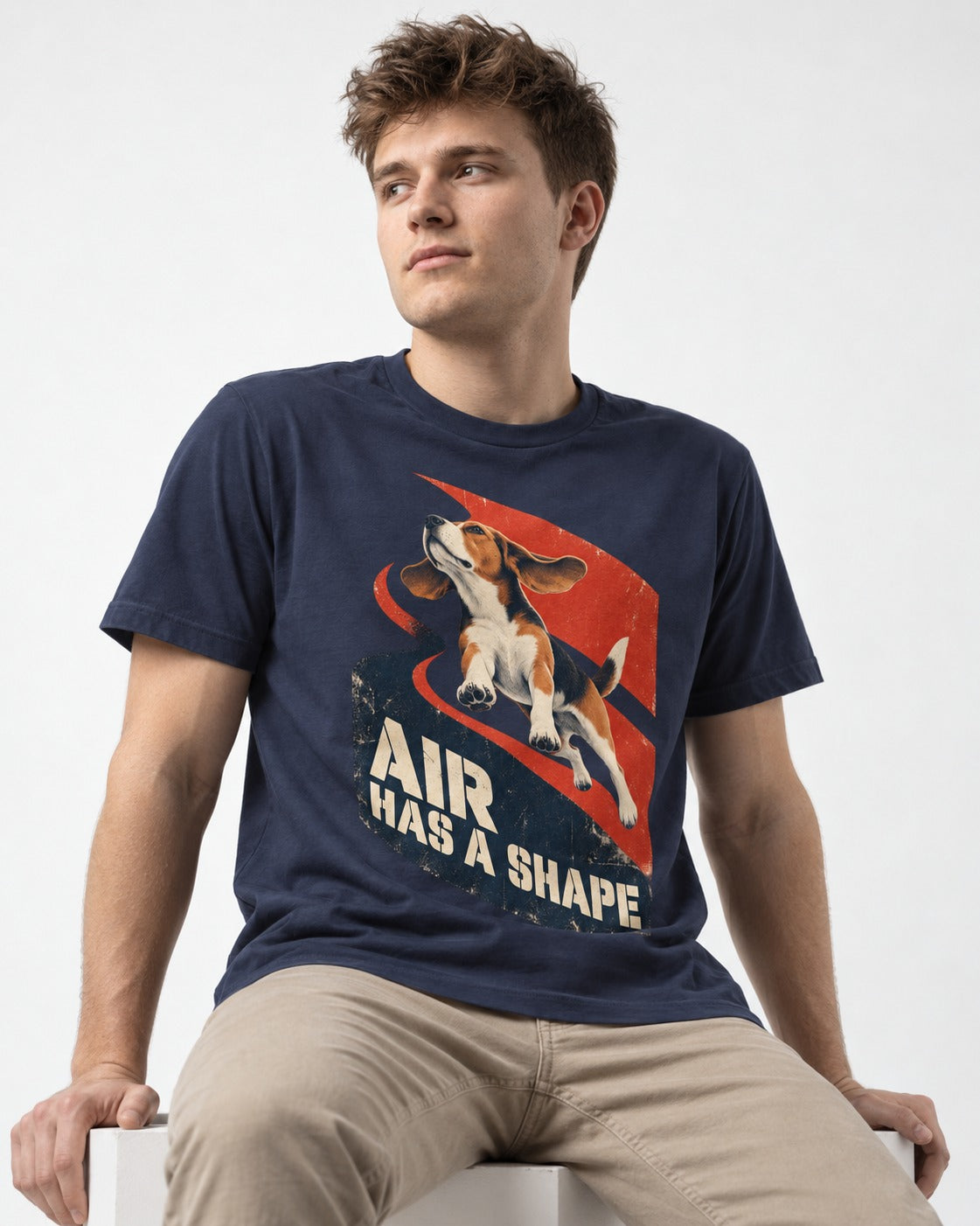 Air Has A Shape Beagle Jumping Graphic T-Shirt in Navy, worn by a seated model