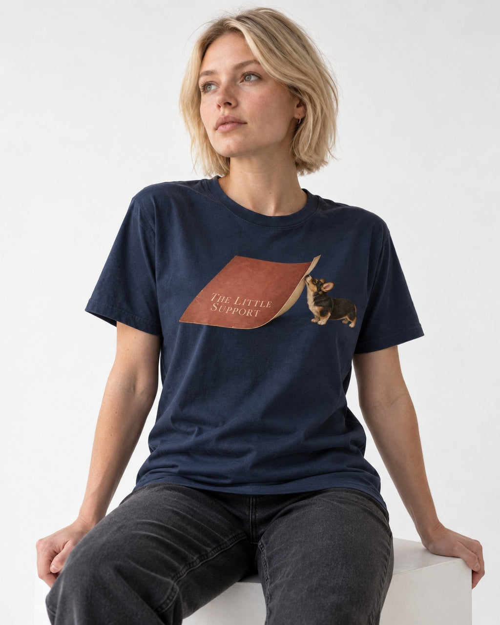 Corgi The Little Support Paper Graphic T-Shirt in Navy, worn by a seated model