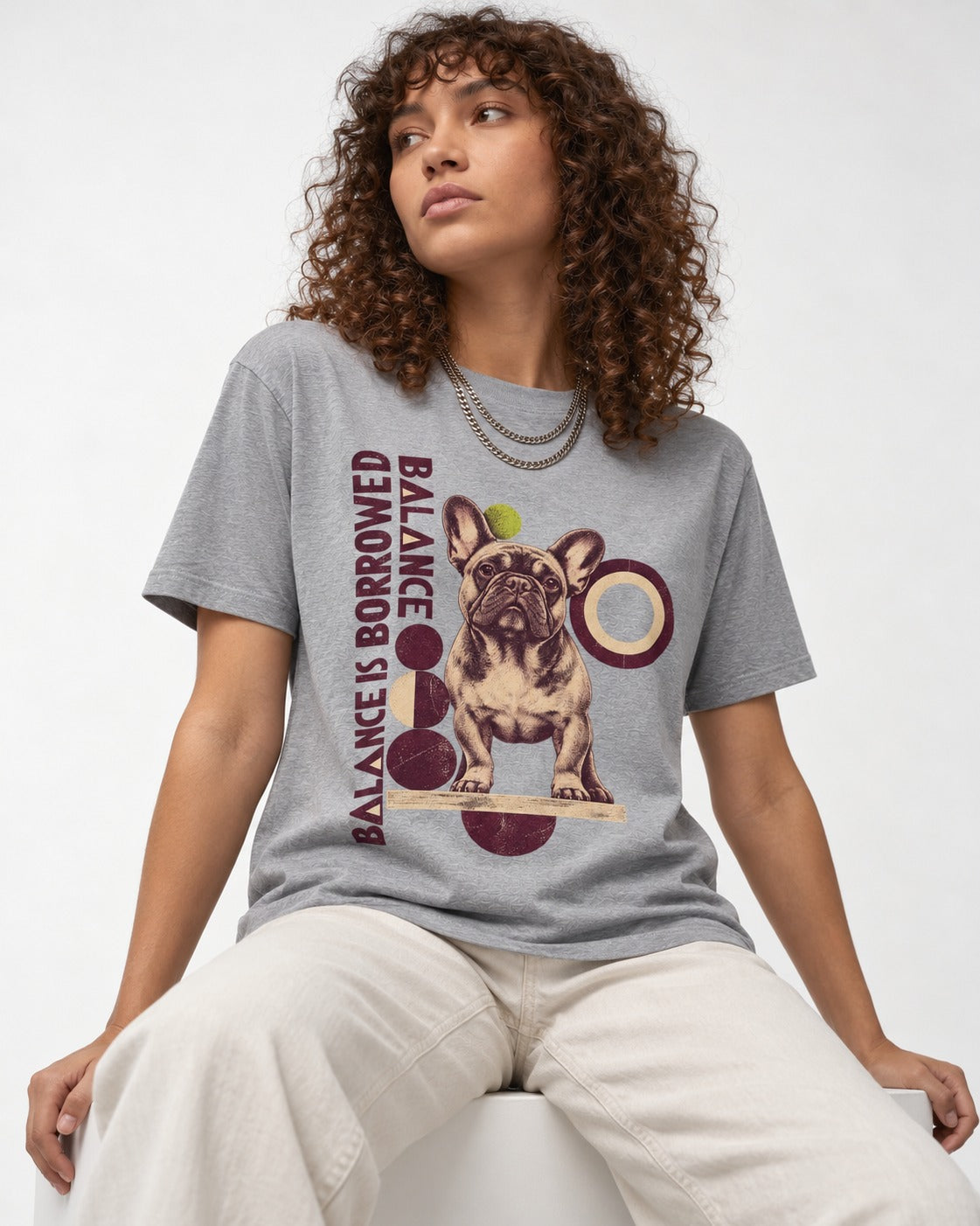 Frenchie's Balance Is Borrowed T-Shirt in Sport Grey, worn by a seated model