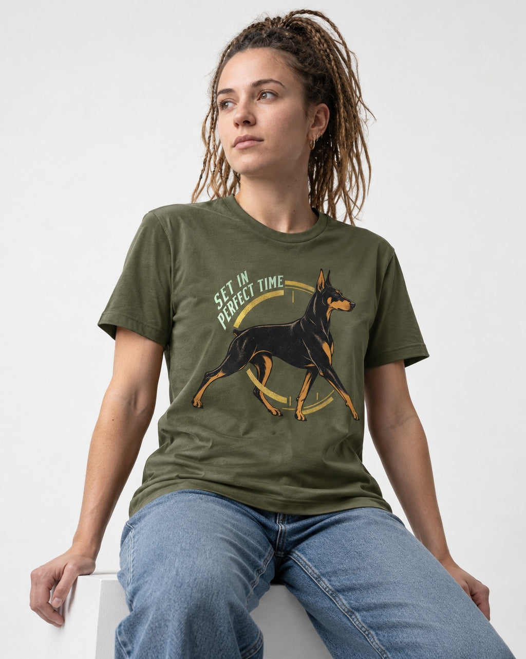 Doberman Set in Perfect Time Clock Stride Graphic T-Shirt in Heather Military Green, worn by a seated model