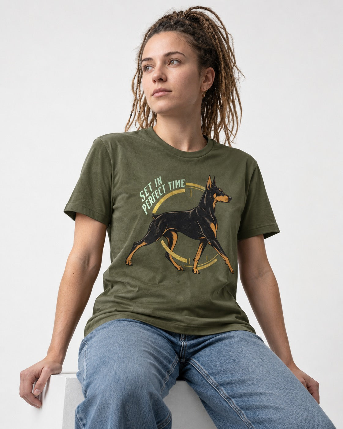 Doberman Set in Perfect Time Clock Stride Graphic T-Shirt in Heather Military Green, worn by a seated model
