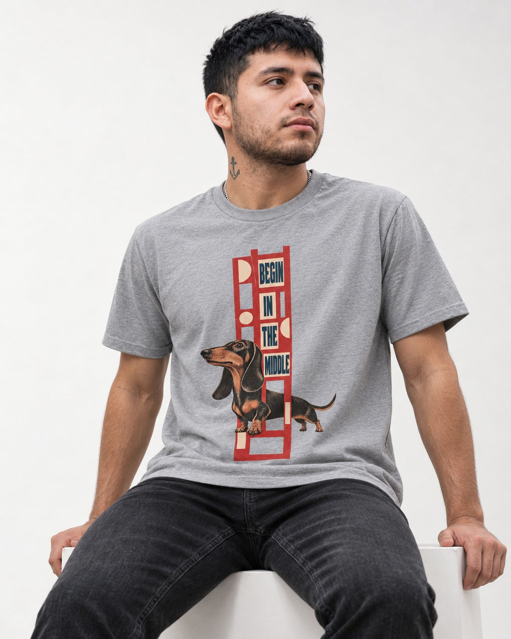 Dachshund Begins in the Middle T-Shirt in Sport Grey, worn by a seated model