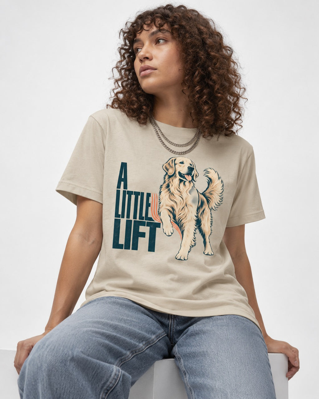A Little Lift Golden Retriever T-Shirt in Sand, worn by a seated model