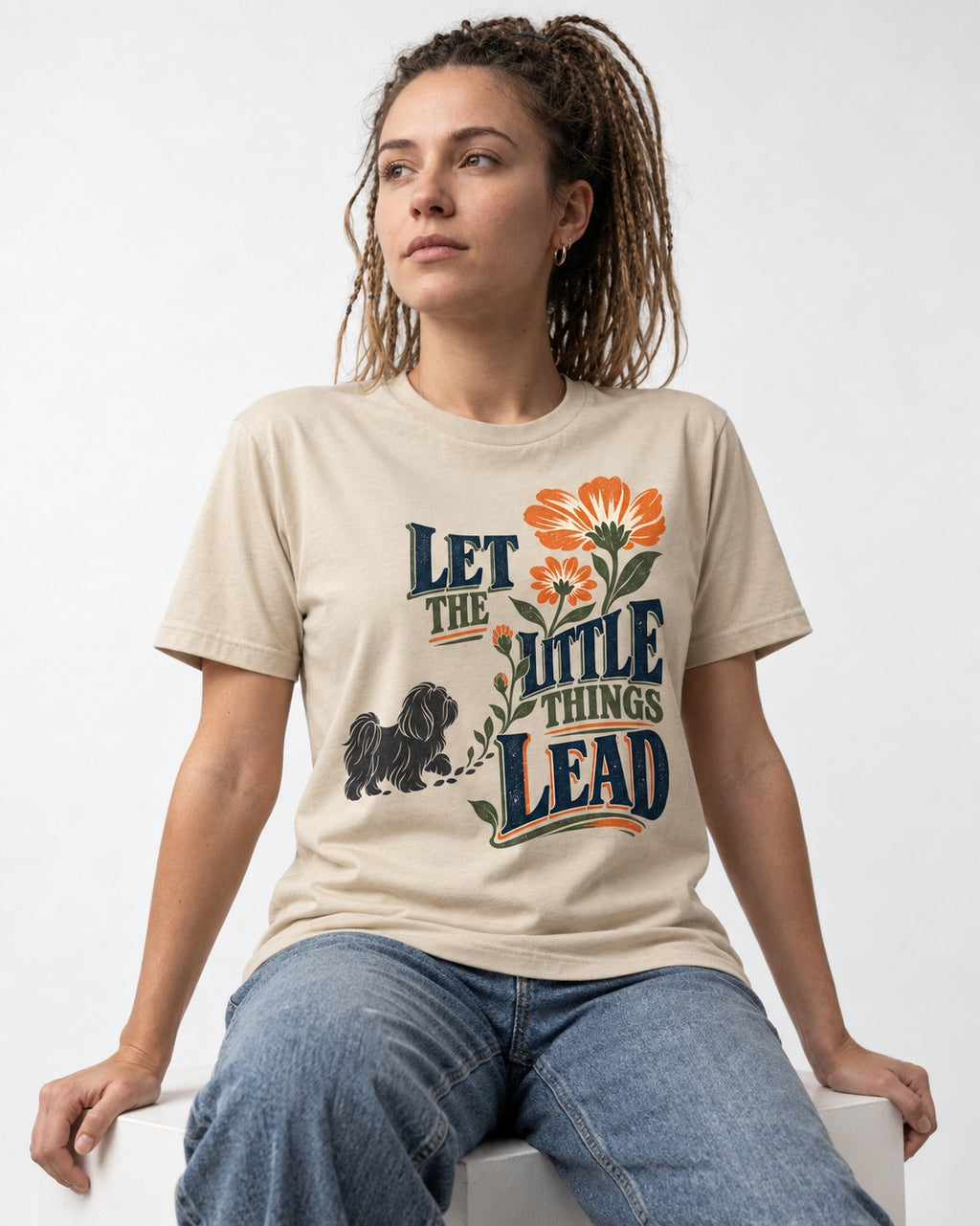 Let the Shih Tzu Lead T-Shirt in Sand, worn by a seated model
