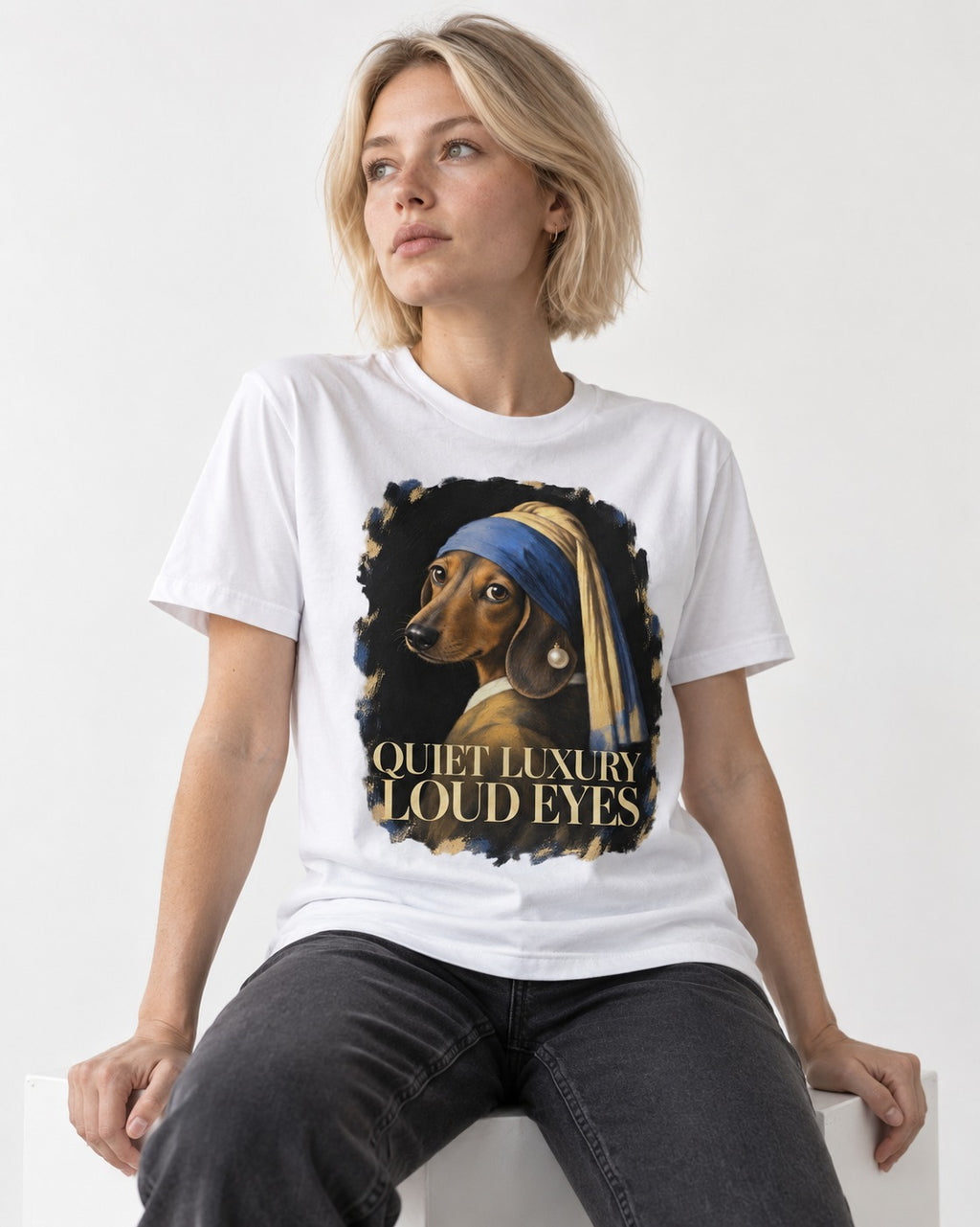 Dachshund Quiet Luxury Loud Eyes Pearl Portrait Graphic T-Shirt in White, worn by a seated model