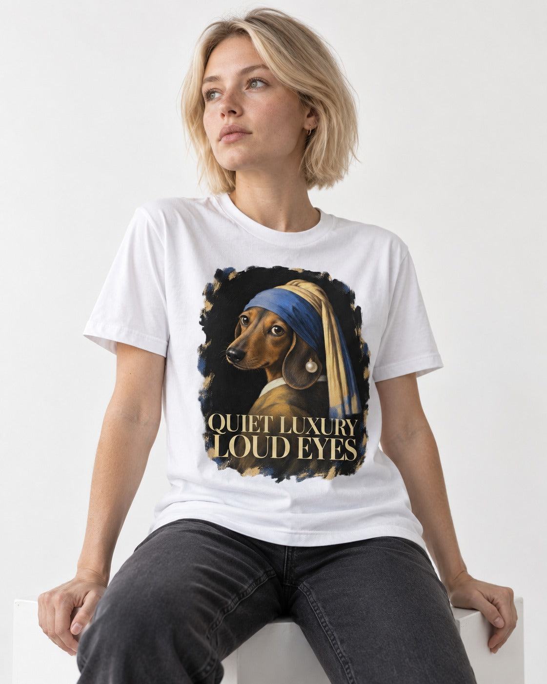 Dachshund Quiet Luxury Loud Eyes Pearl Portrait Graphic T-Shirt in White, worn by a seated model