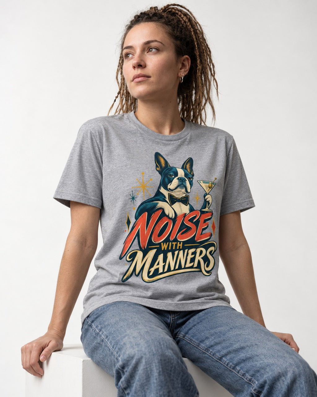 Boston Terrier Noise With Manners Cocktail Graphic T-Shirt in Sport Grey, worn by a seated model