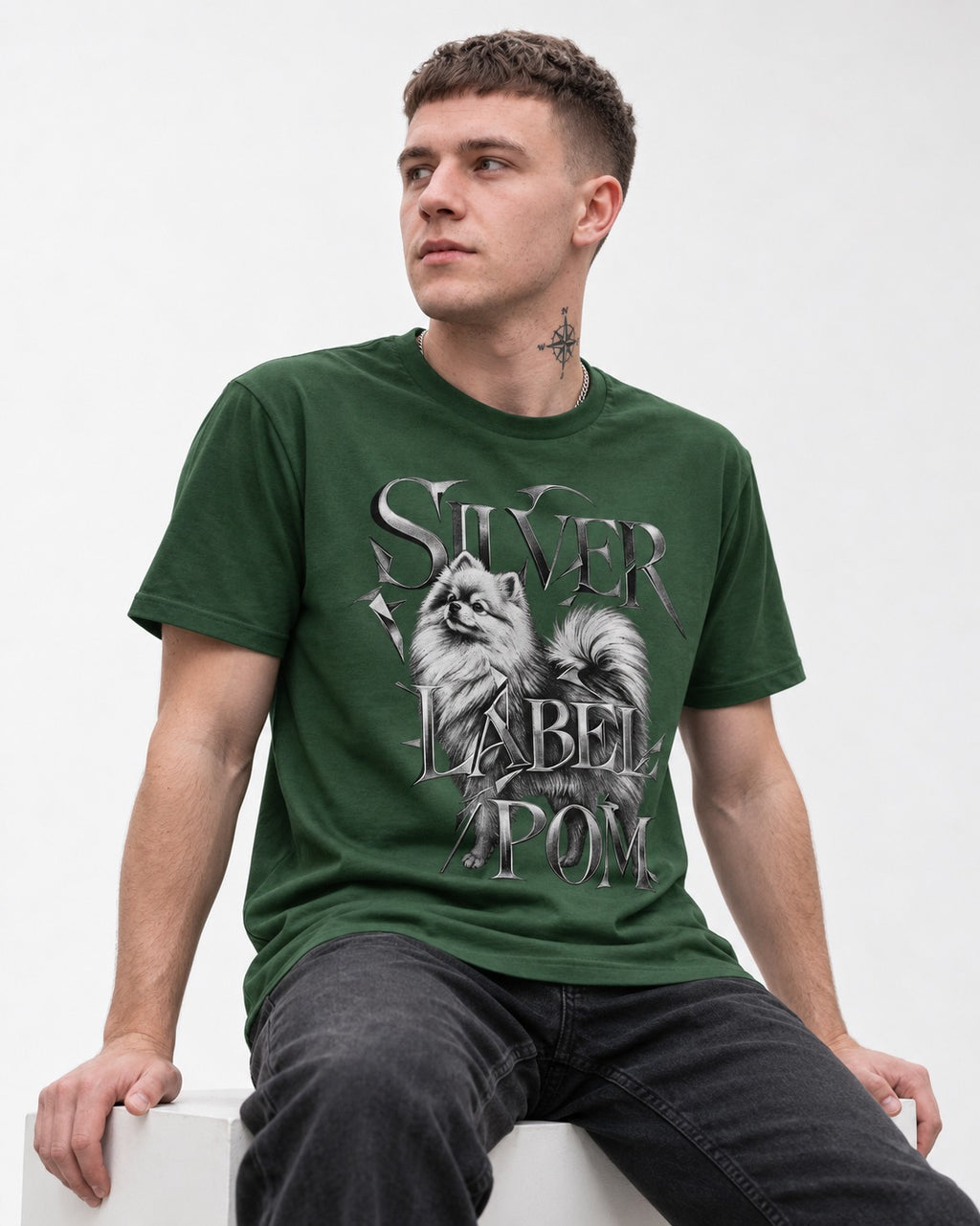 Pomeranian Silver Label Metallic Typography Graphic T-Shirt in Forest Green, worn by a seated model