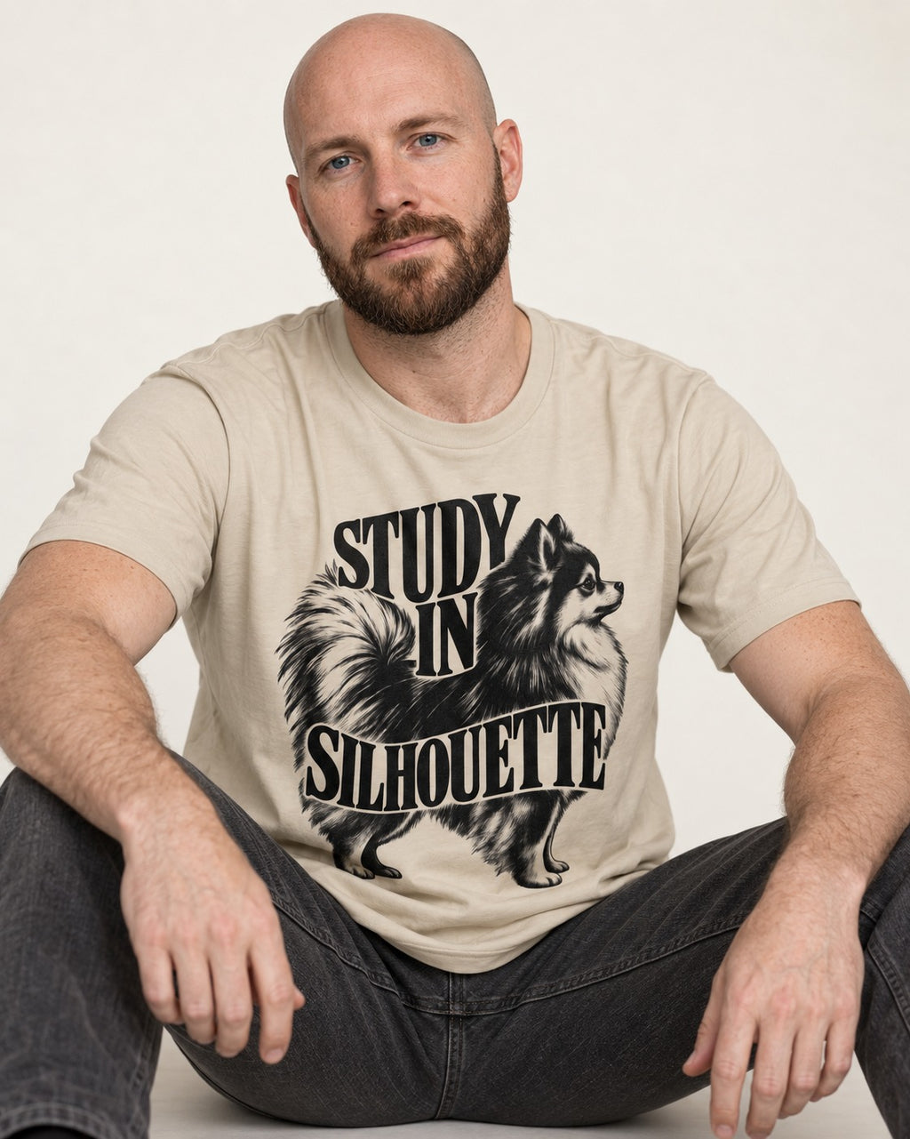 Pomeranian Study in Silhouette T-Shirt in Sand, worn by a seated model