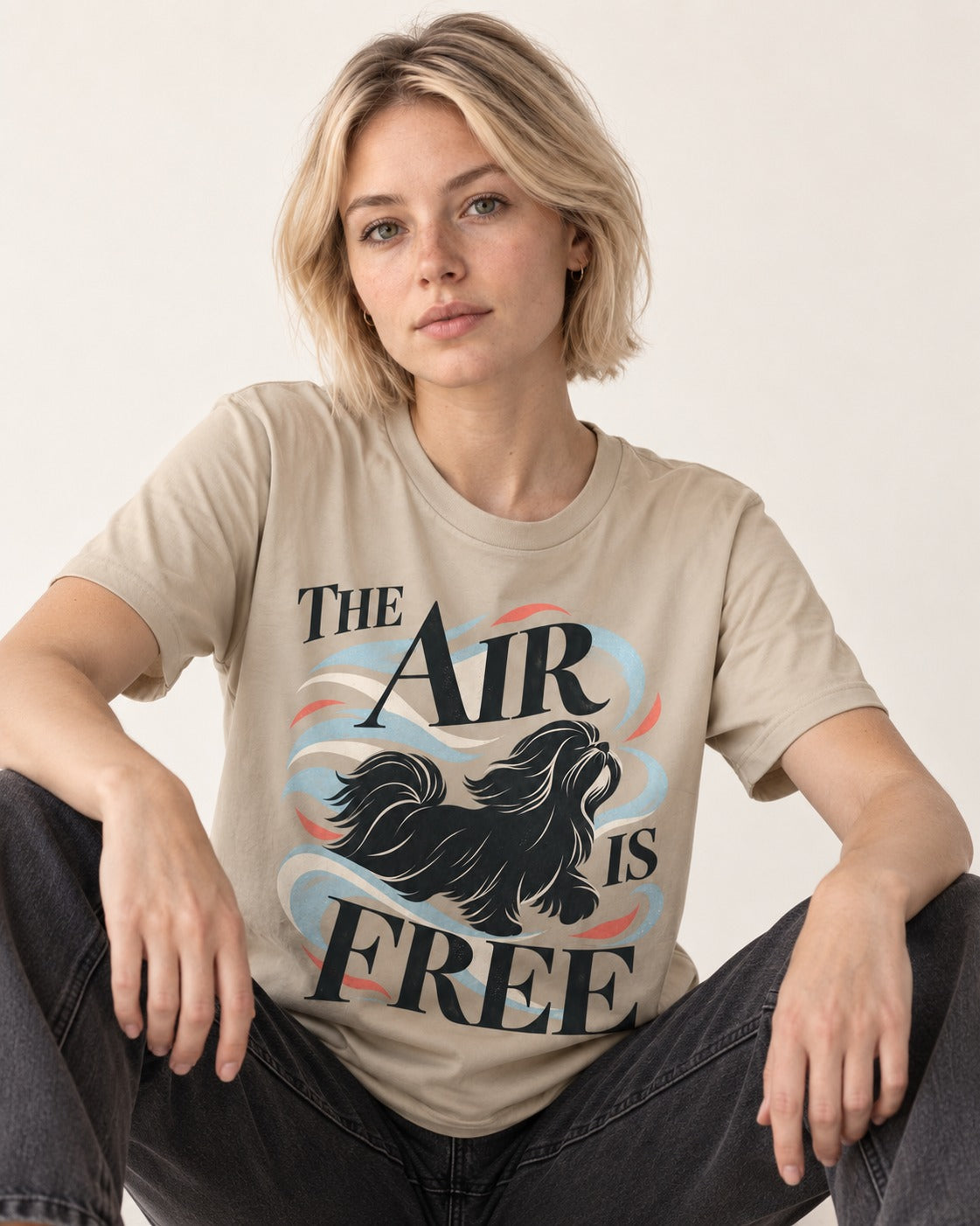 The Air Is Free Shih Tzu T-Shirt in Sand, worn by a seated model