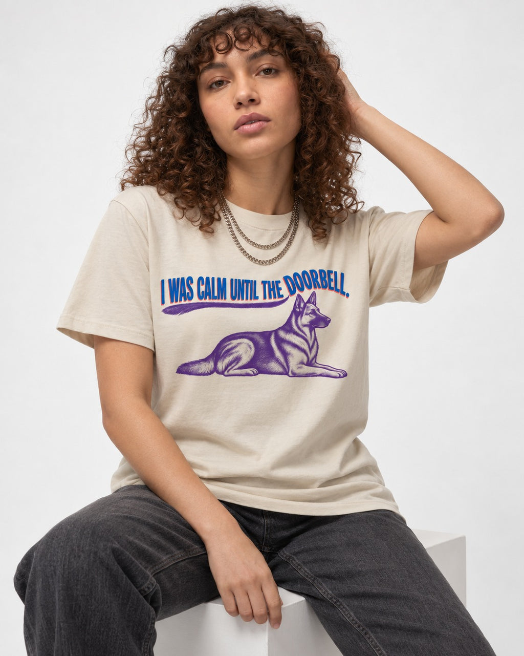 German Shepherd Dog Calm Until the Doorbell T-Shirt in Sand, worn by a seated model