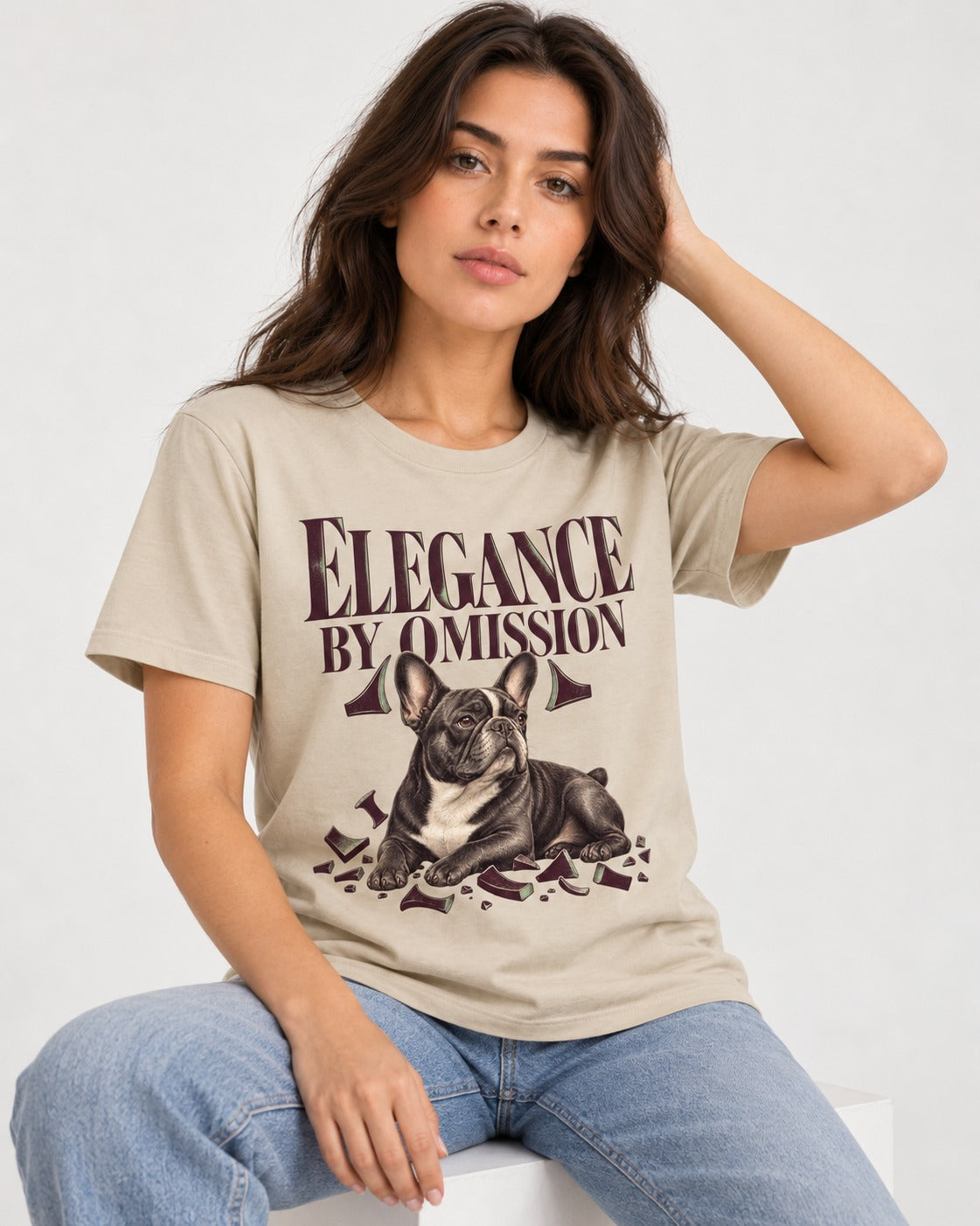 Frenchie Elegance by Omission T-Shirt in Sand, worn by a seated model