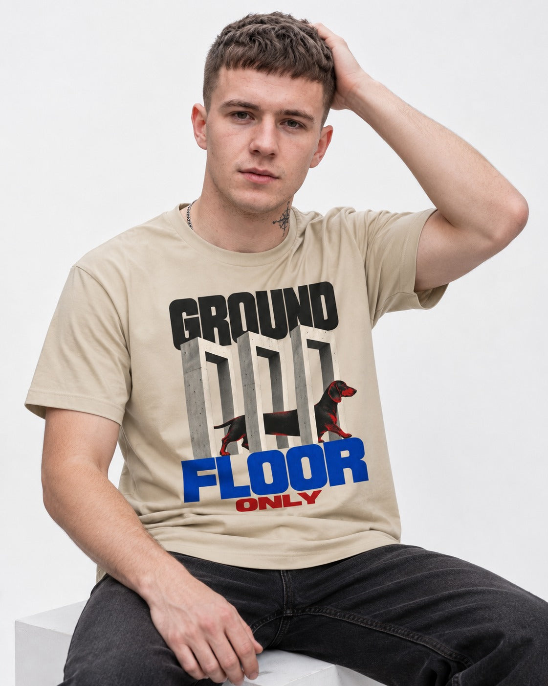 Ground Floor Only Dachshund T-Shirt in Sand, worn by a seated model