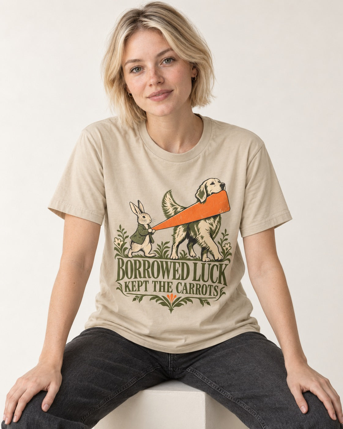 Borrowed Luck Golden Retriever T-Shirt in Sand, worn by a seated model