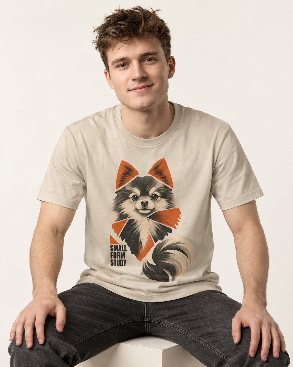 Pomeranian Small Form Study T-Shirt in Sand, worn by a seated model