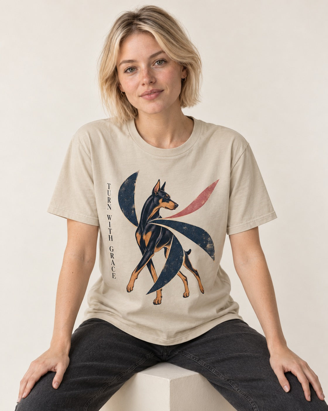 Turn with Doberman Grace T-Shirt in Sand, worn by a seated model