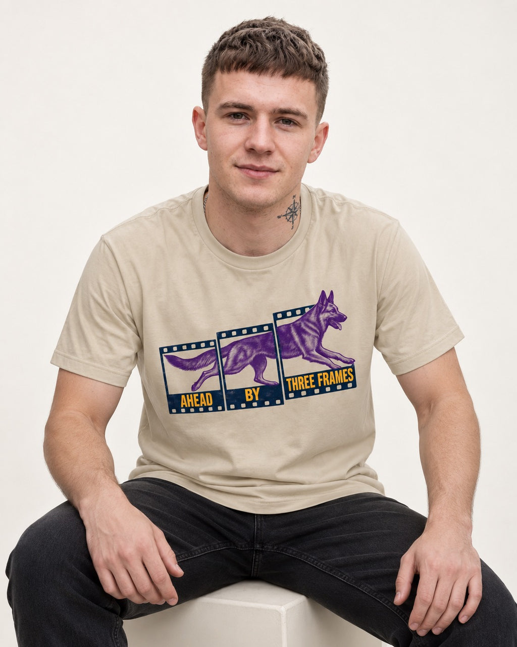 German Shepherd Dog Ahead by Three Frames T-Shirt in Sand, worn by a seated model