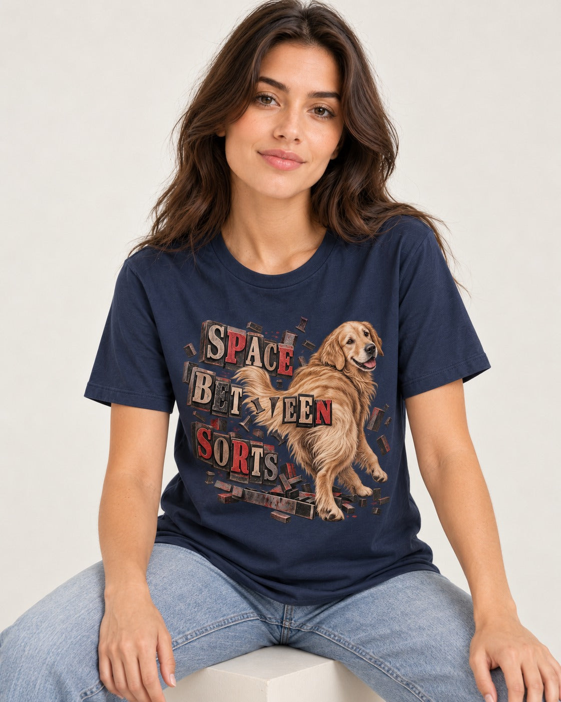 Golden Retriever Space Between Sorts Letterpress Graphic T-Shirt in Navy, worn by a seated model