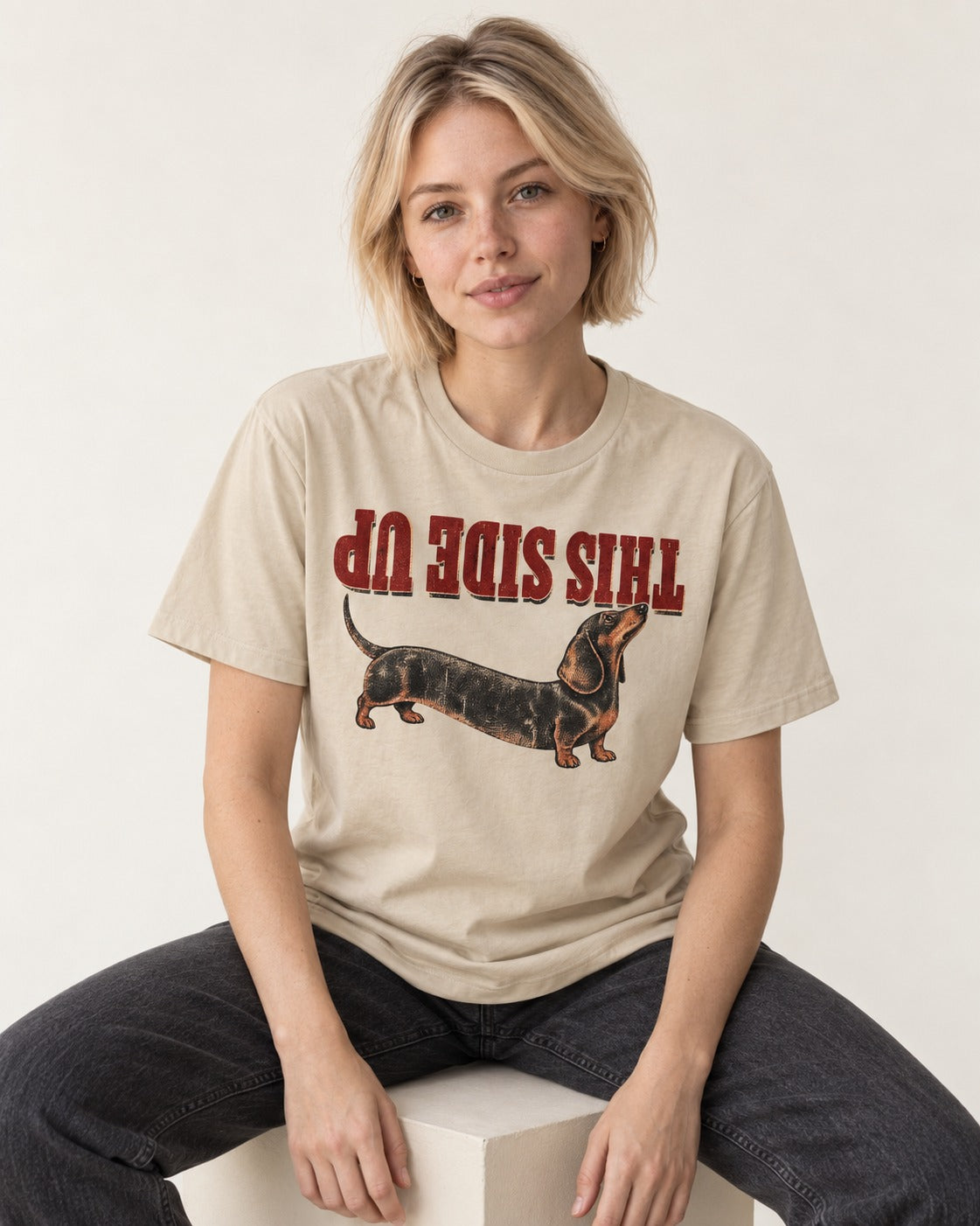 This Side Up Dachshund T-Shirt in Sand, worn by a seated model