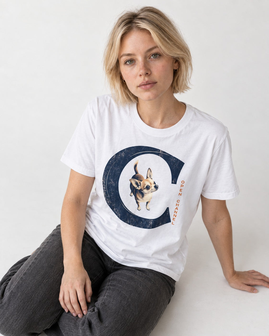 Chihuahua Open Channel T-Shirt in White, worn by a seated model