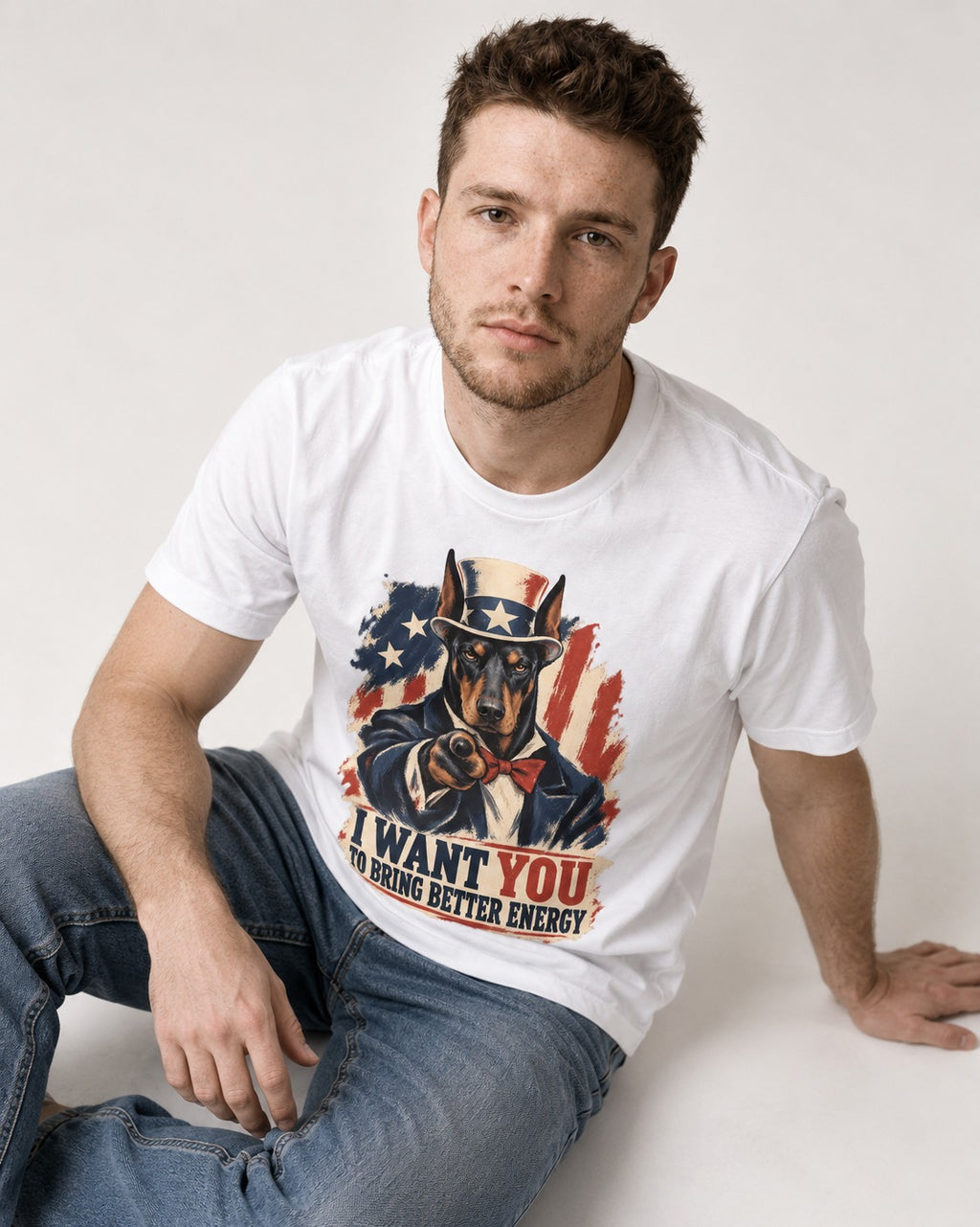 Doberman I Want You to Bring Better Energy Uncle Sam Graphic T-Shirt in White, worn by a seated model
