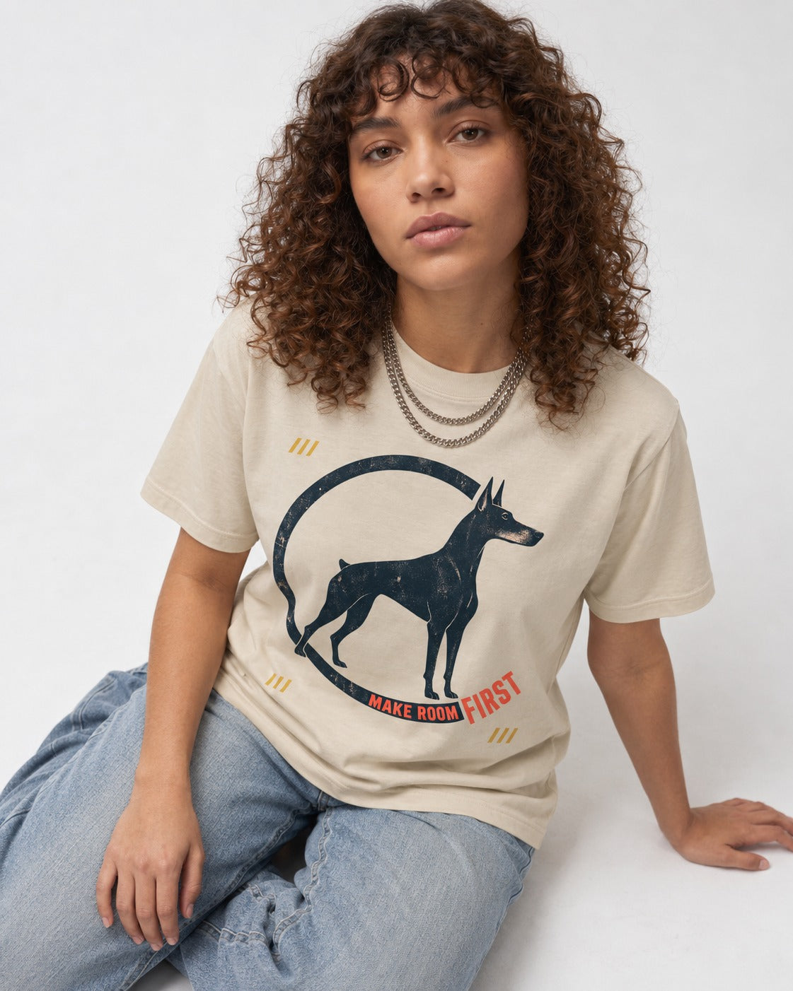 Make Room First Doberman T-Shirt in Sand, worn by a seated model