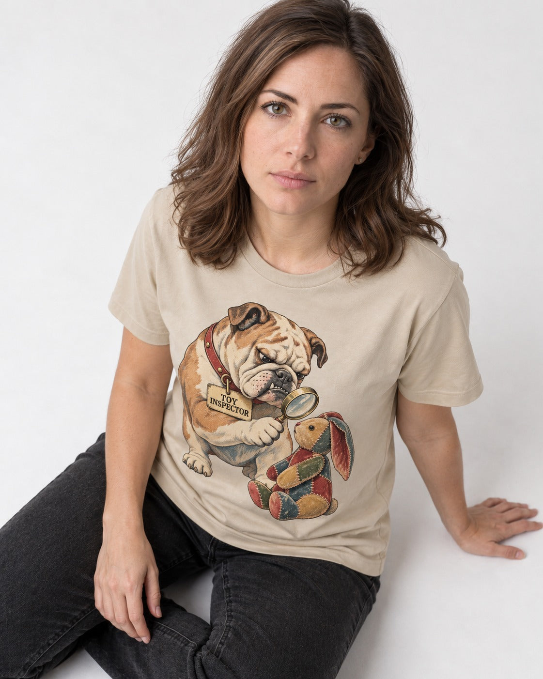 English Bulldog Toy Inspector T-Shirt in Sand, worn by a seated model