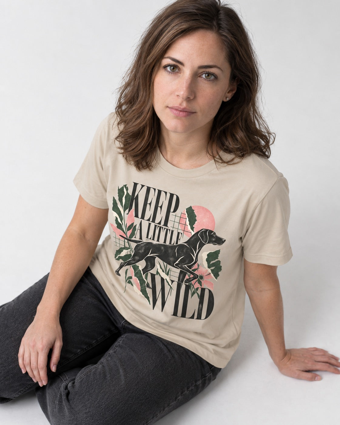Keep a Little Wild German Shorthaired Pointer T-Shirt in Sand, worn by a seated model