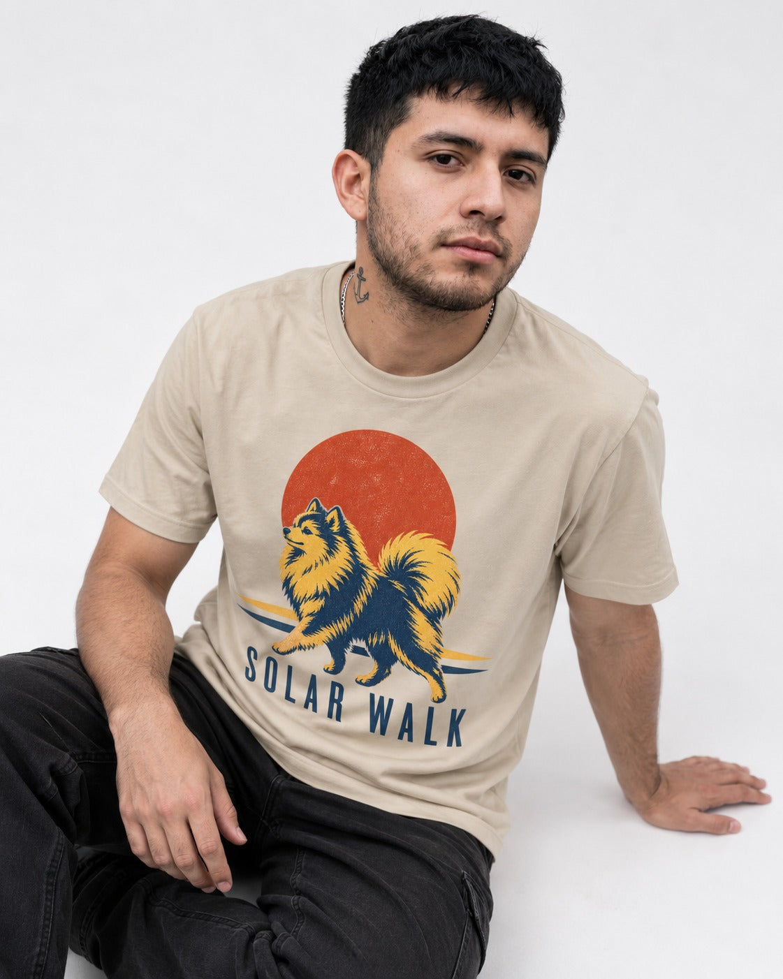 Pomeranian Solar Walk T-Shirt in Sand, worn by a seated model