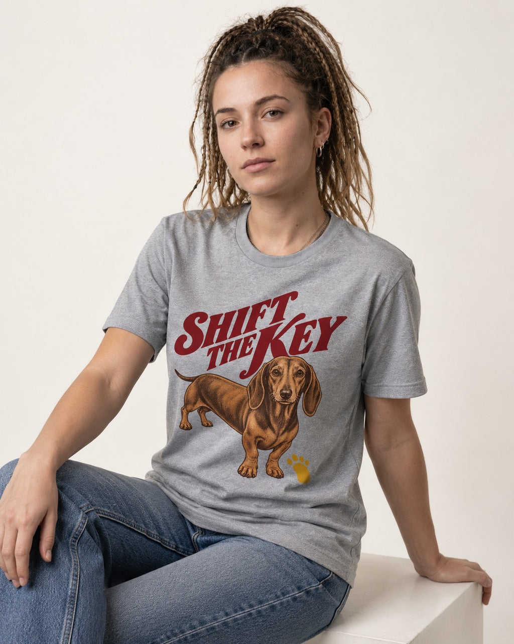 Dachshund Shift The Key Pawprint Graphic T-Shirt in Sport Grey, worn by a seated model