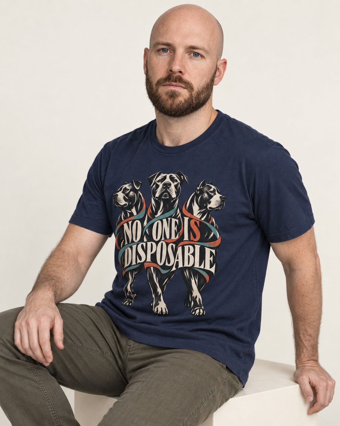 Pitbull No One Is Disposable Three Dogs Graphic T-Shirt in Navy, worn by a seated model