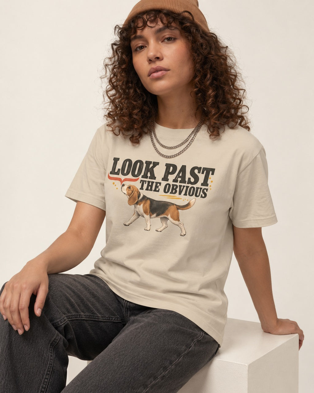 Beagle Look Past the Obvious T-Shirt in Sand, worn by a seated model