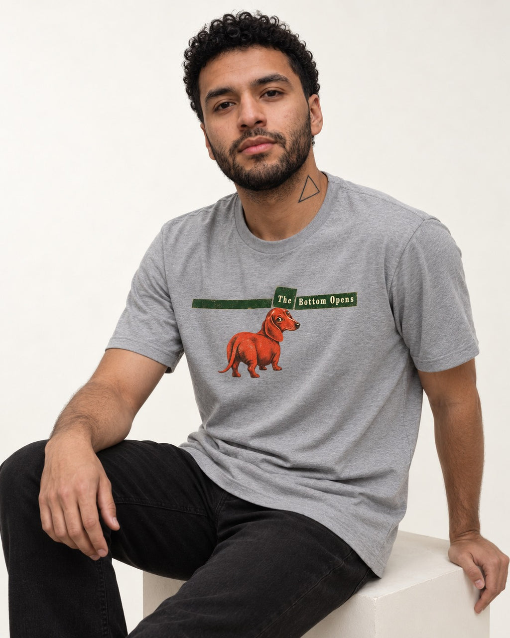 Dachshund The Bottom Opens Signpost Graphic T-Shirt in Sport Grey, worn by a seated model